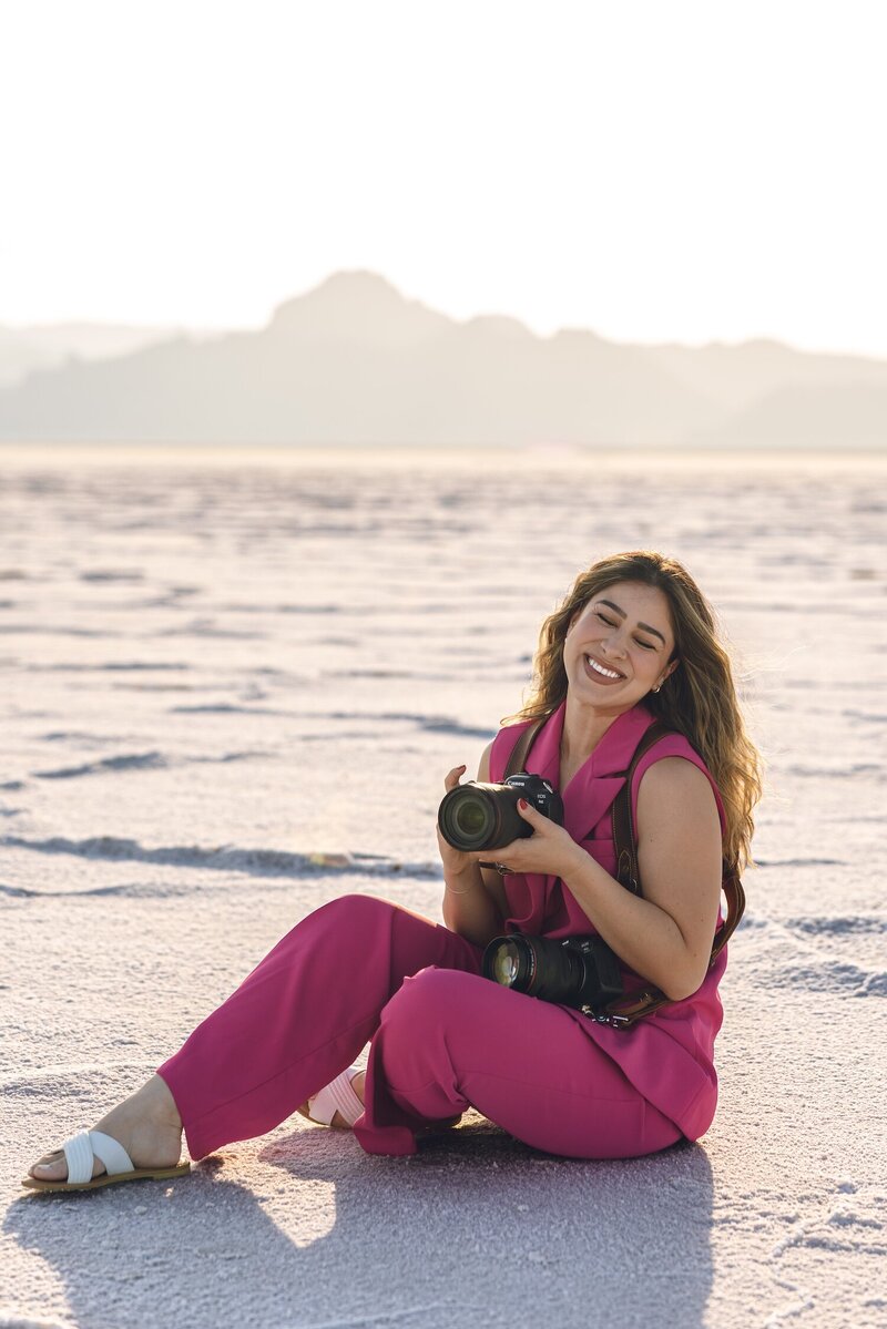 Karen Michelle walking on the beach with camera, candid brand photo for photographer bio