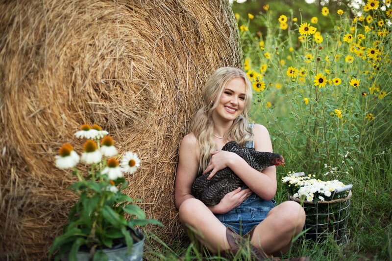 high school senior pictures farm themed shoot girls dreessed in ovralls posing with red tractor