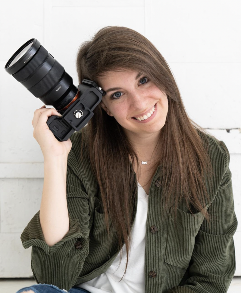Photographer posing for a headshot with a camera