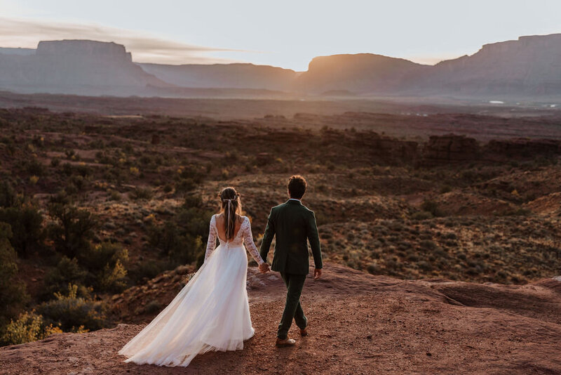 bride and groom walking in the desert