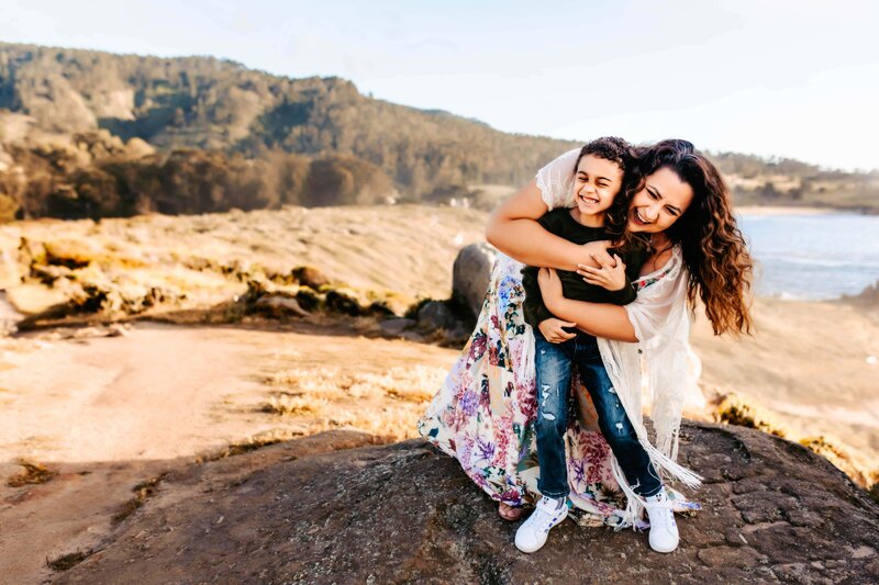 Morgen and her son hugging each other while standing on top of a hill in Newport Beach