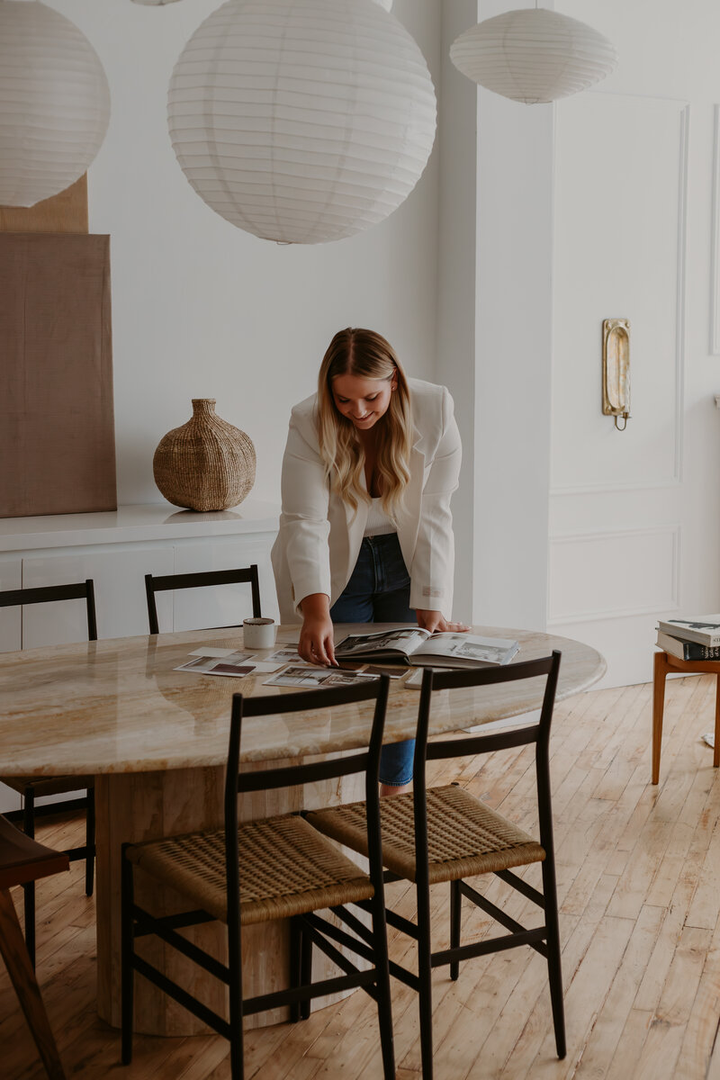 business women leaning over a dining table arranging project materials