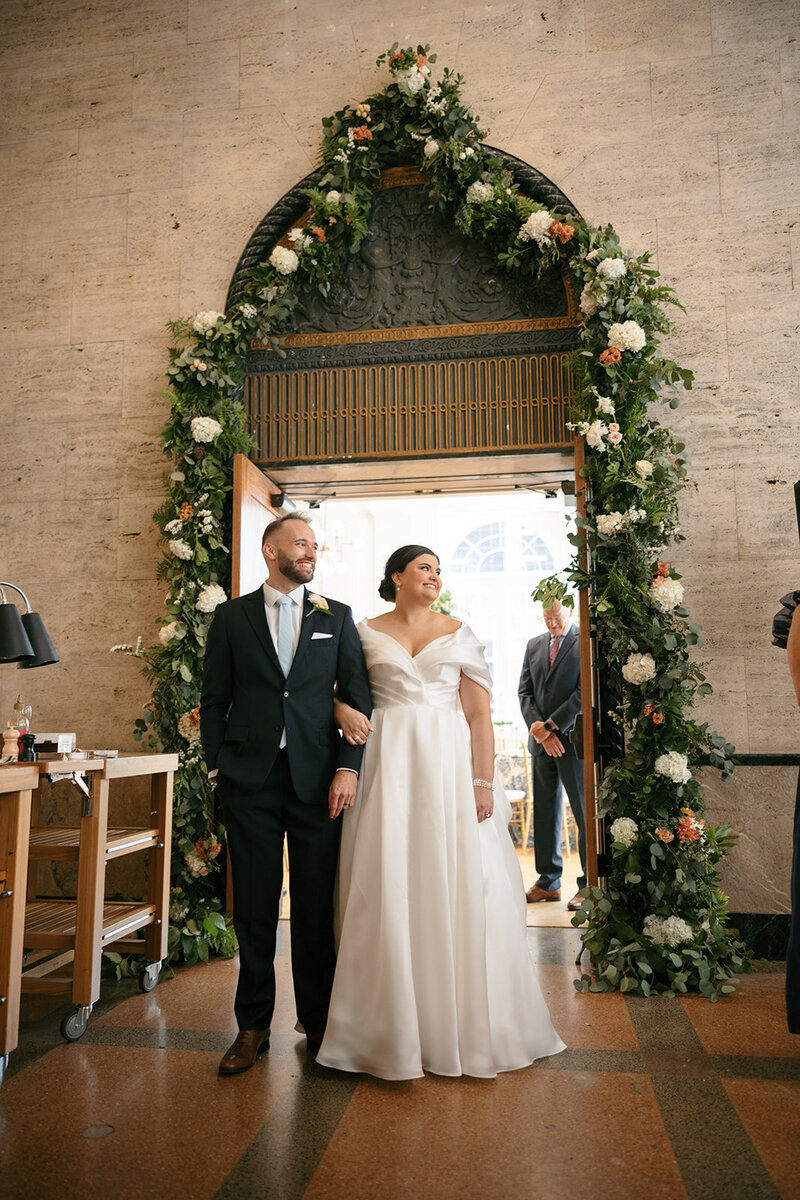 Warm, nostalgic image of bride and groom under floral arbor at Nashville wedding