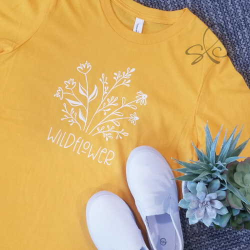 Yellow t-shirt with custom illustration of wildflowers and text "wildflower"