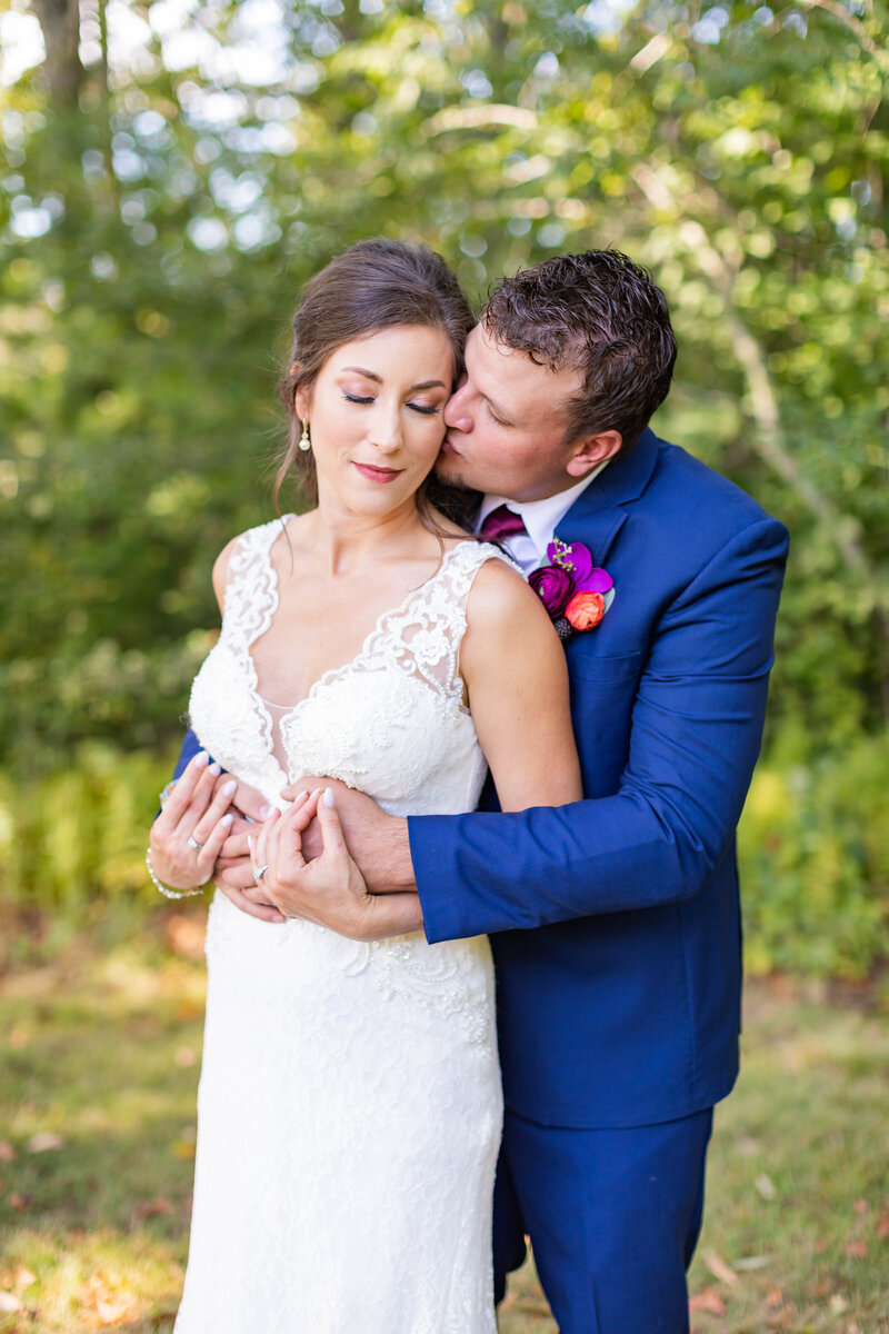 Groom kisses bride on the cheek in South Carolina outdoor wedding photoshoot by TMP.
