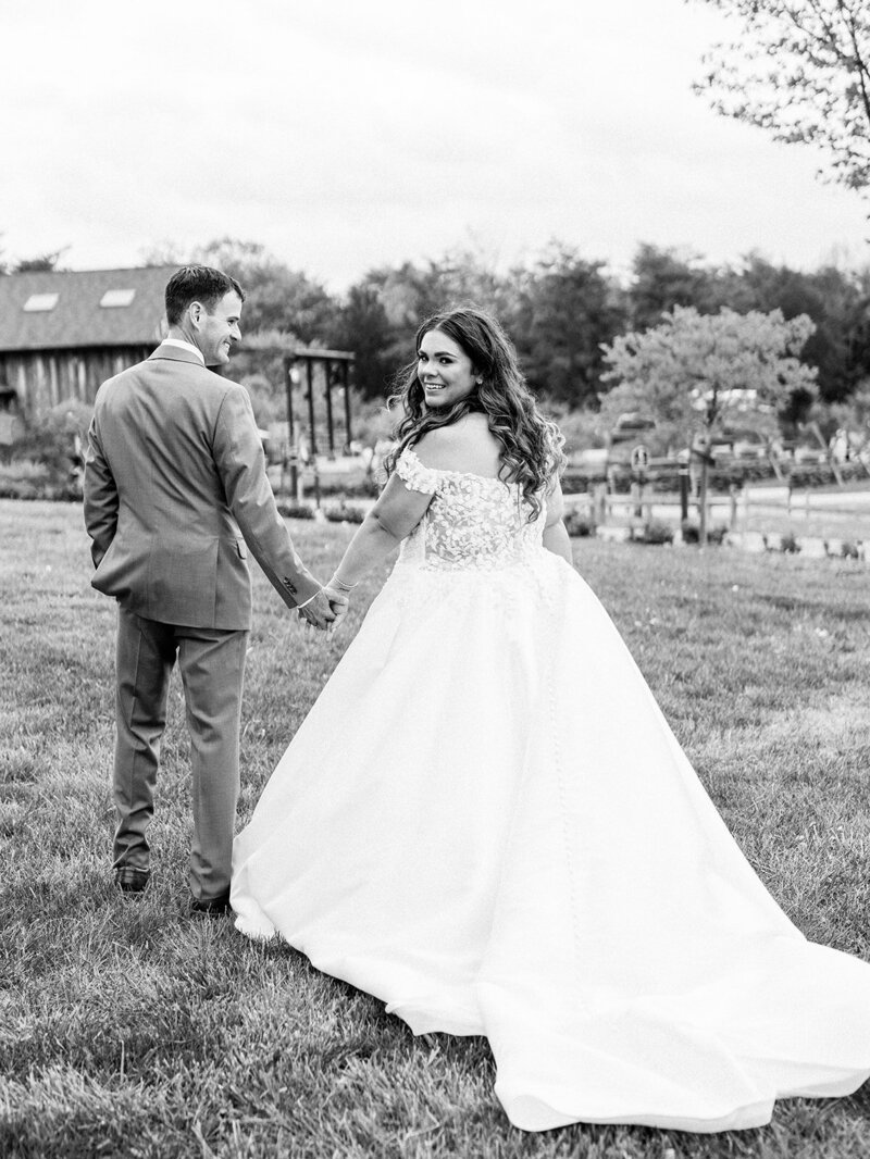 Bride looks back to the camera as  the groom looks at her