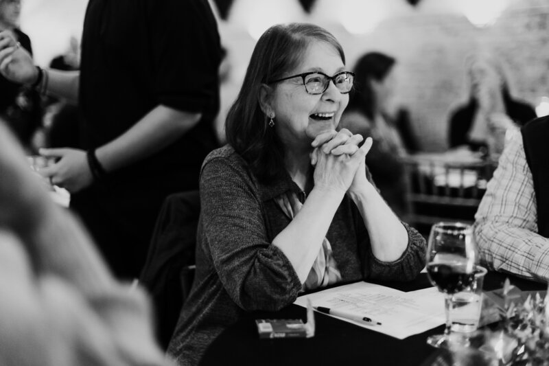 black and white photo woman laughing in a crowd
