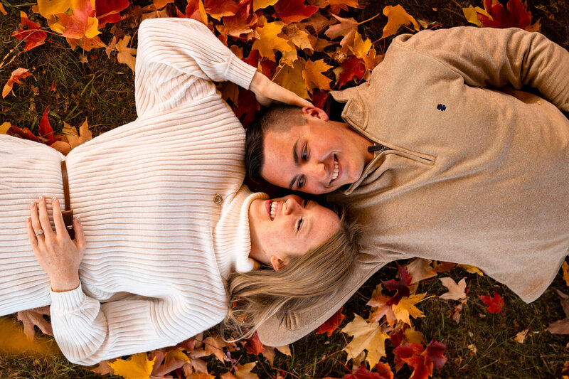 Aerial engagement portrait of couple holding each other in autumn leaves at a sunset portrait session near Beaver county, PA
