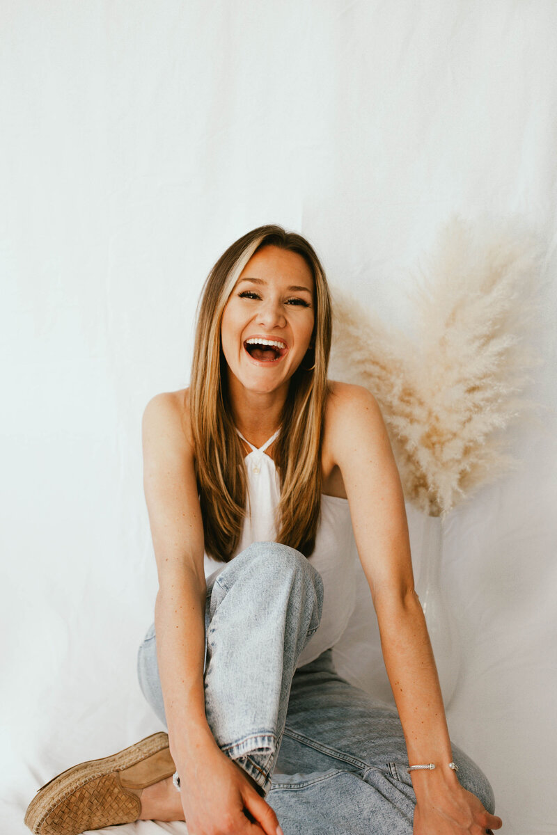 woman sitting smiling with pampas grass