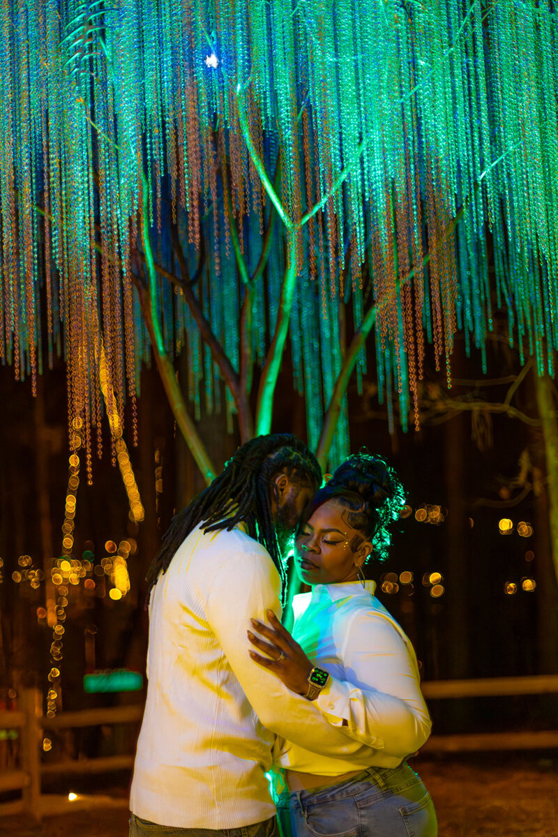 Couple embracing under glowing hanging lights at night