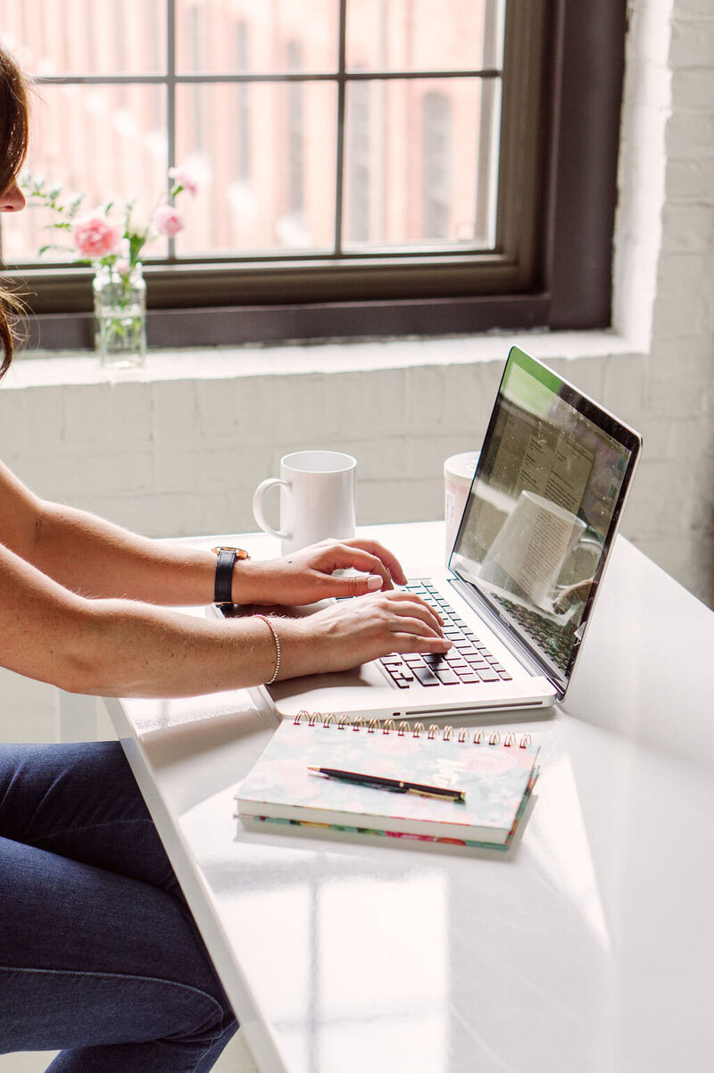 woman in comfy close sitting at a glass desk