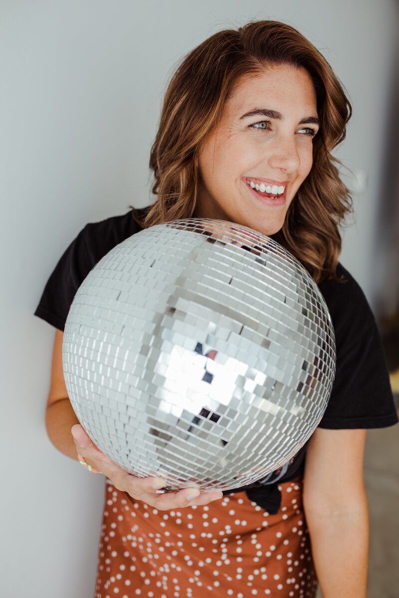 Photographer in studio holding disco ball