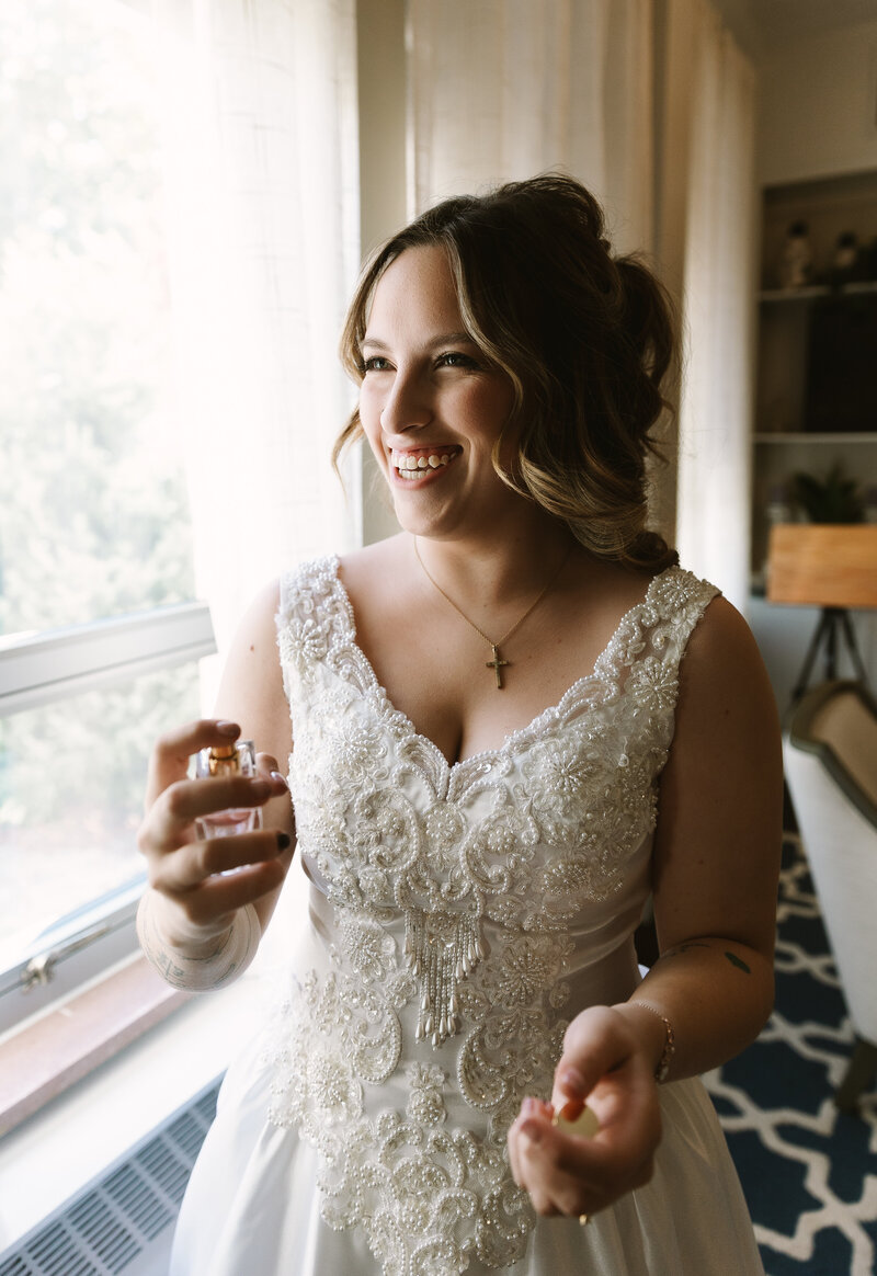 Bride getting ready for wedding and spraying perfume