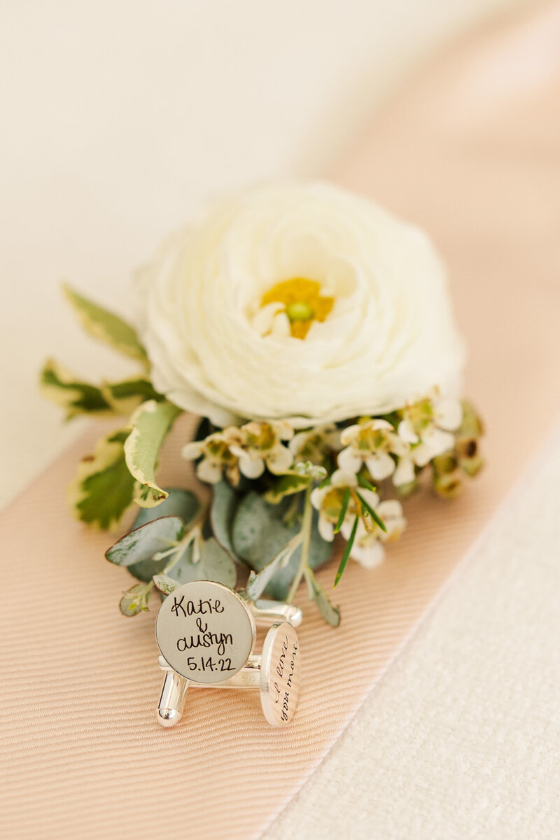 Groom's boutonniere with pink tie and engraved cufflinks with wedding date. Waukesha photographer.
