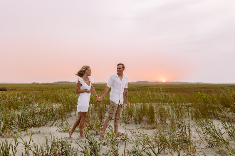 a couple walking together on folly beach in charleston south carolina 