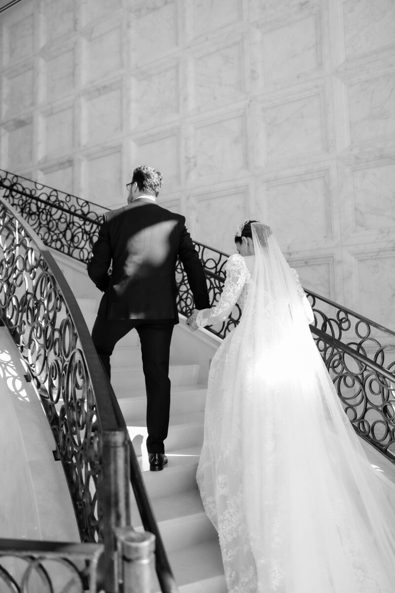 Black and white photo  of bride and groom portrait on the grand staircase at a wedding at the four seasons Orlando by Florida wedding photographer.