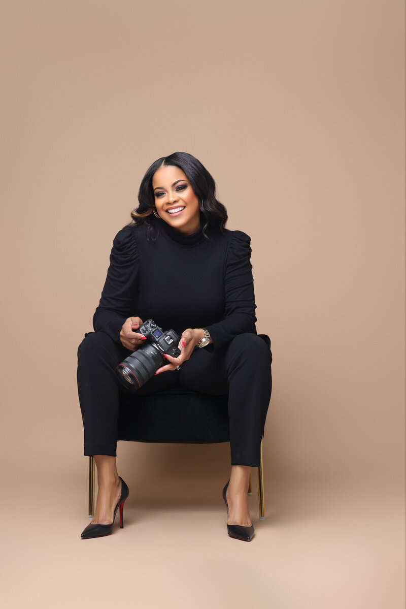 Angela smiling while holding a camera