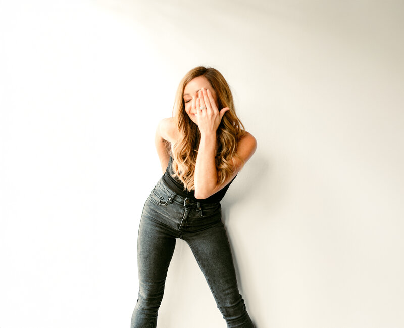 Candid portrait of Shannon O'Malley, Twin Cities portrait and online dating photographer, laughing naturally during a branding photo session, reflecting her fun and approachable style.