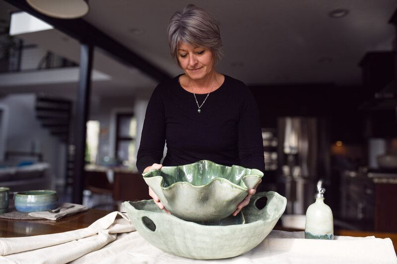 Jill sets the table with a large green wave bowl and a large green serving bowl with handles