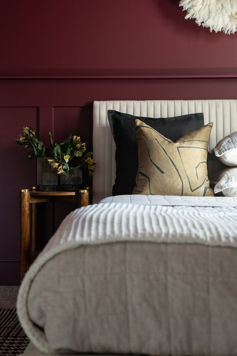 a bedroom with deep red walls and gold accents