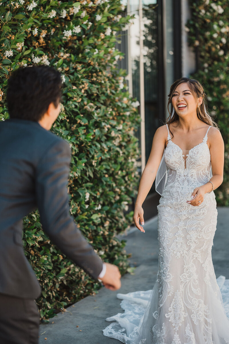 14-radiant-love-events-first-look-outside-grooms-back-leaning-forward-looking-at-bride-laughing-bride-in-focus-romantic-elegant-timeless