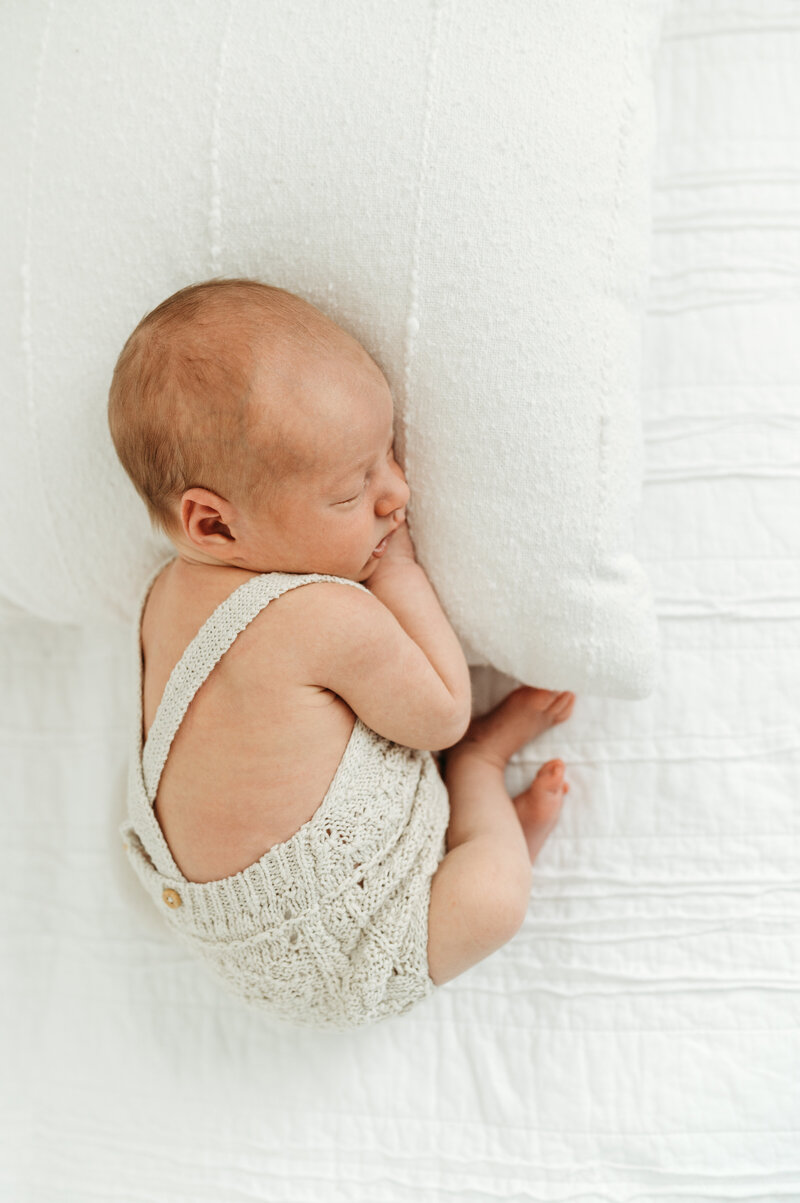 A newborn baby is laying on a pillow  during her newborn session in Atlanta
