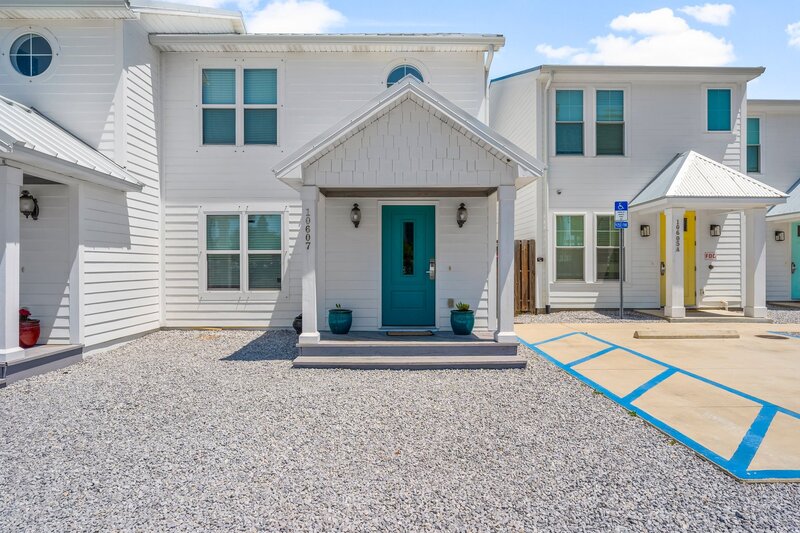Inviting front entry of Tropical House in Panama City Beach featuring a vibrant green door and clean coastal aesthetic.