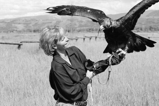 Black and white photo of Leslie Goodyear holding a golden eagle