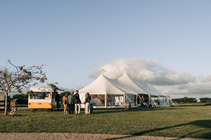 white stretch tents and caravan bar on sunny day at farm chapel wedding venue waimumu near gore