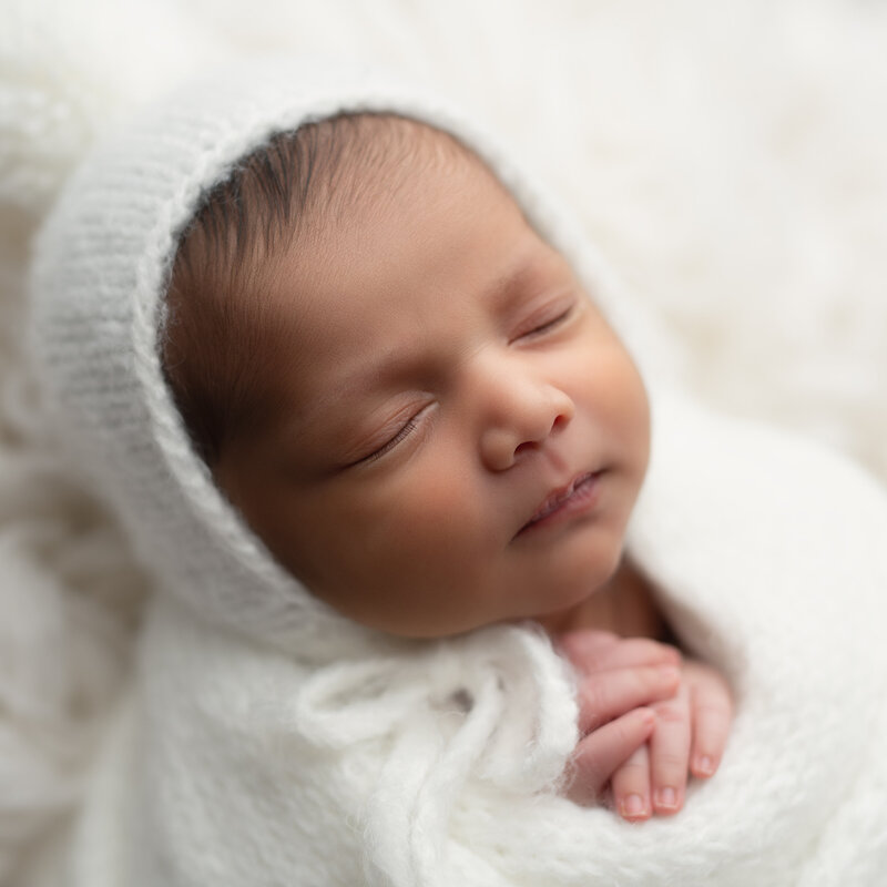 Softly swaddled newborn photographed in natural light—capturing the peaceful beauty of your baby’s earliest moments. Timeless newborn photography in Paris, Ontario.