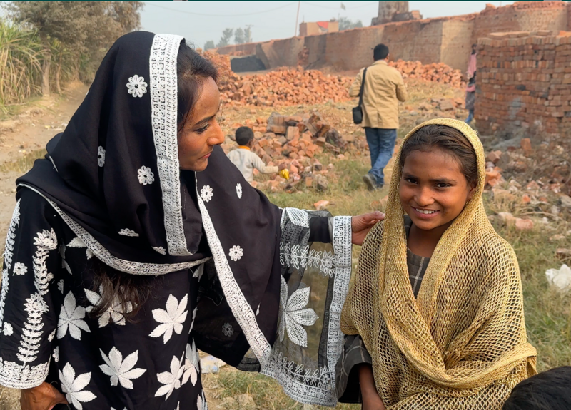 Member of Advocate International stands next to an enslaved child with a supporting hand upon the child's shoulder.