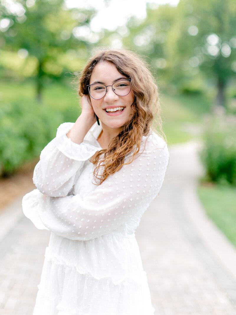 close up photo of high school senior in white dress smiling
