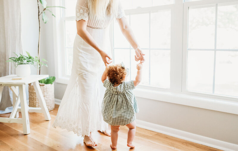 mom helping toddler walk