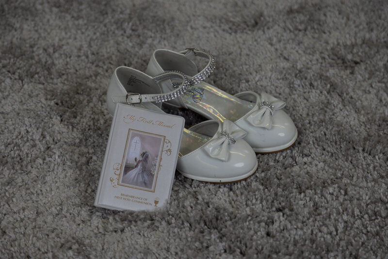 Communion photo of shoes and prayer book on grey rug