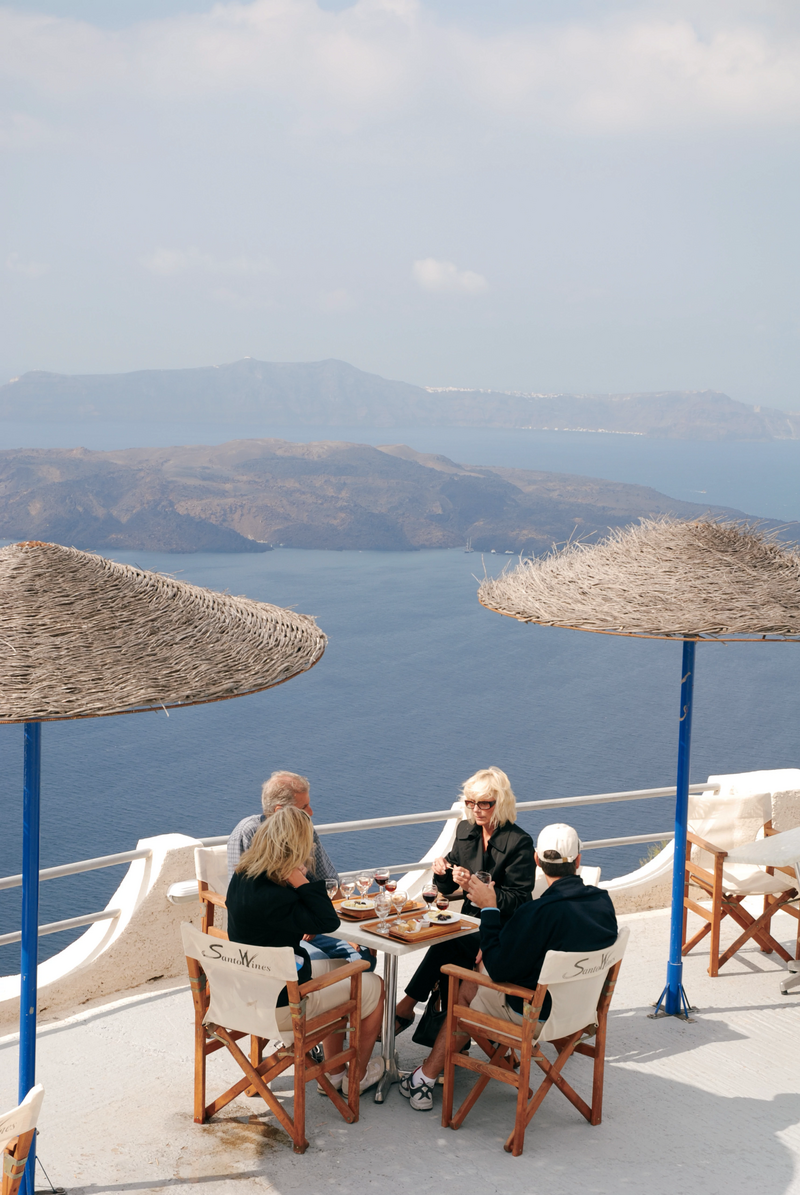 People sit around a table in Santorini