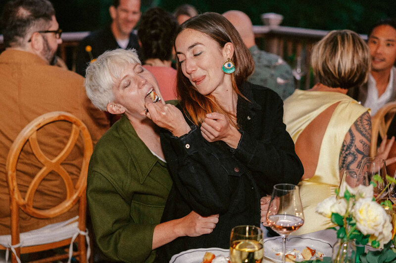two guests feeding each other at the dinner table