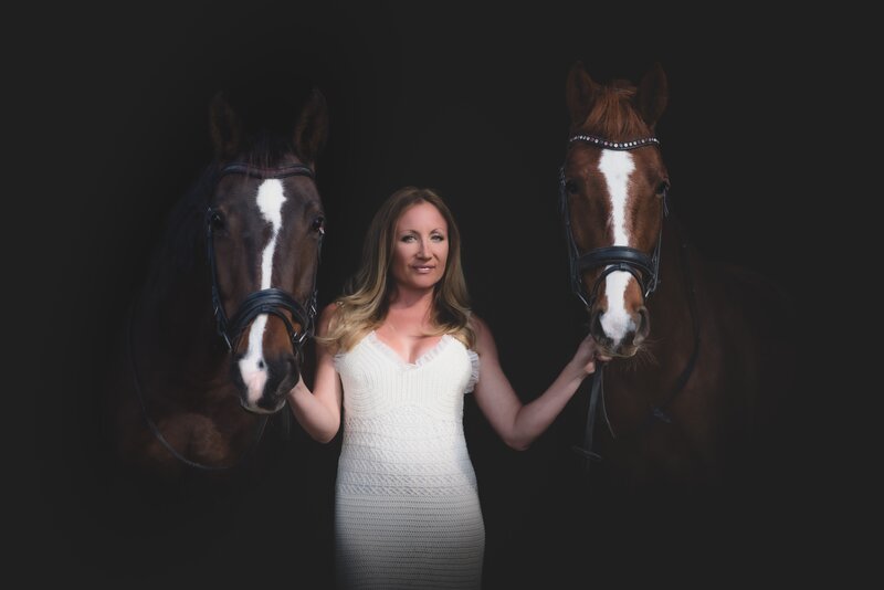 Women photographed with her two horses on a black background