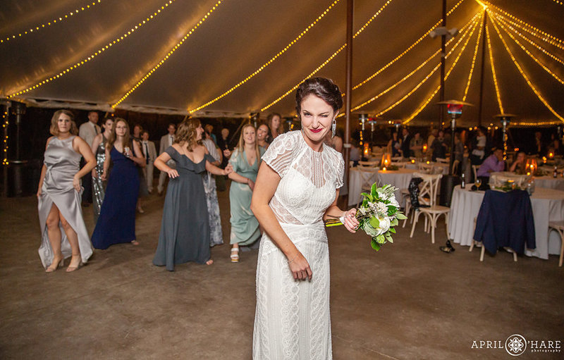 Bride winks before tossing her wedding bouquet at Blackstone RIvers Ranch