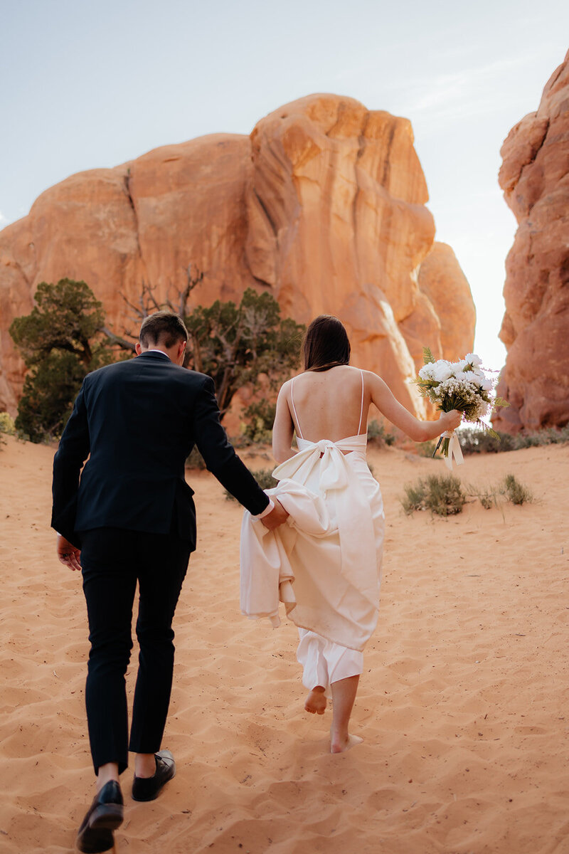 couple walking up hill during wedding photos