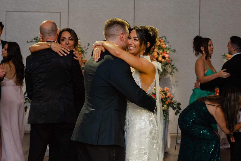 a groom hugs his bride on the dance floor during their Chateau Le Parc wedding reception.  Captured by Ottawa wedding photographer JEMMAN Photography