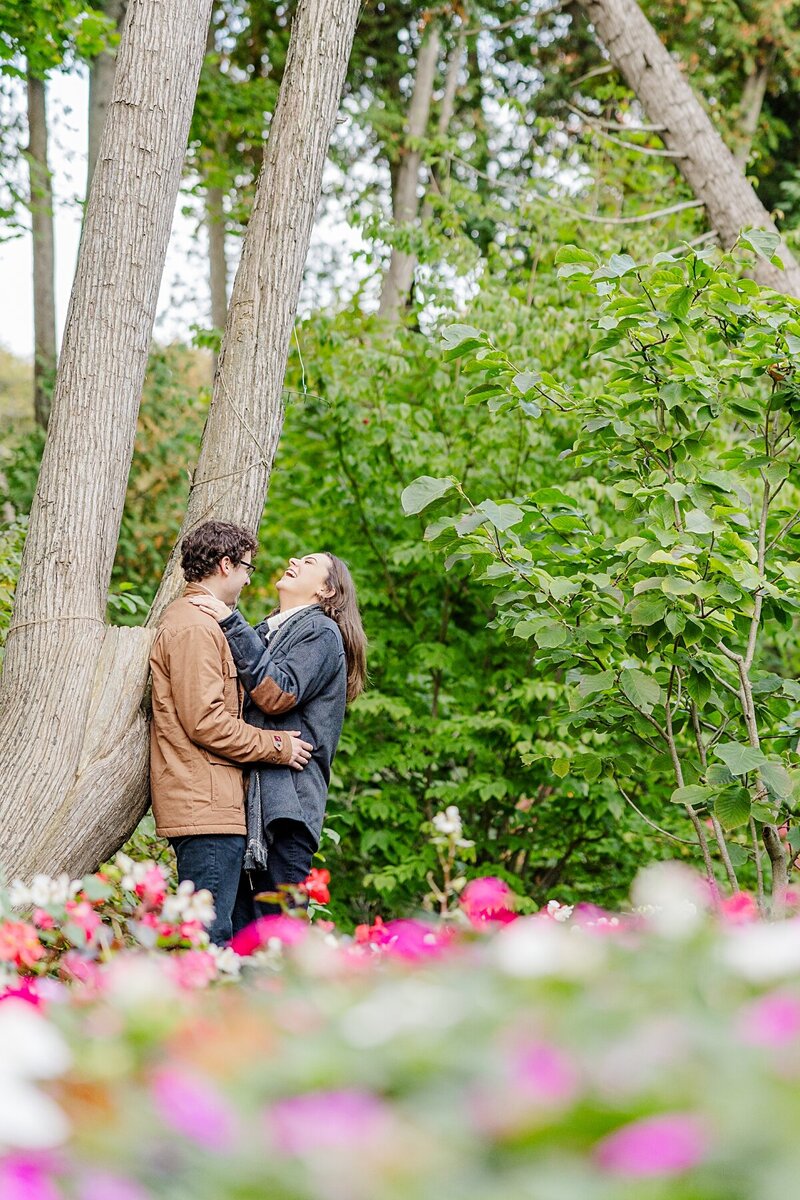 couple-laughing-by-tree-in-flower-garden-mackinac-island
