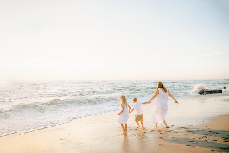 beautiful family walking at the beach in san diego enjoying their photography by Mattie Taylor Photography