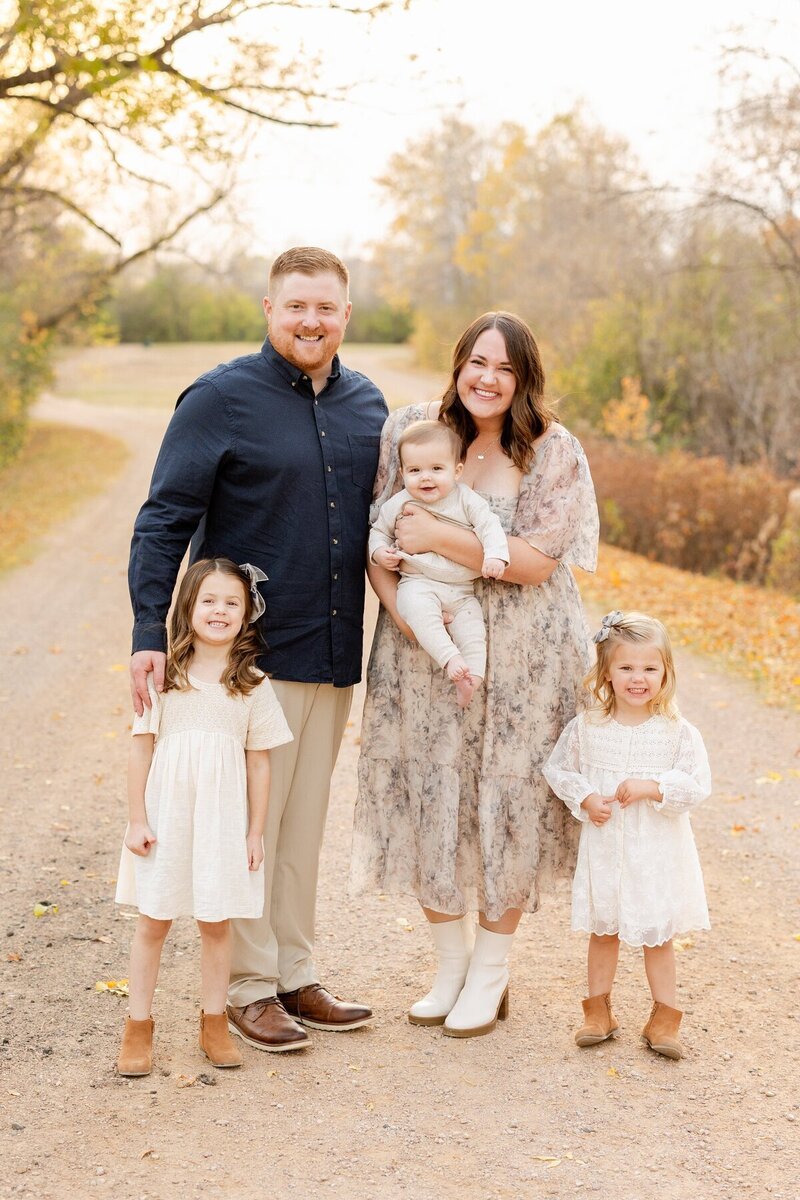 Family of five with three kids smiling on a path at minneapolis family photographer Kacey Wyrick Photography