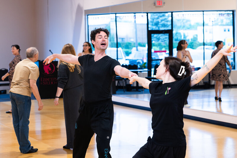 Couple learning ballroom dancing from their instructor at Dancers Studio.