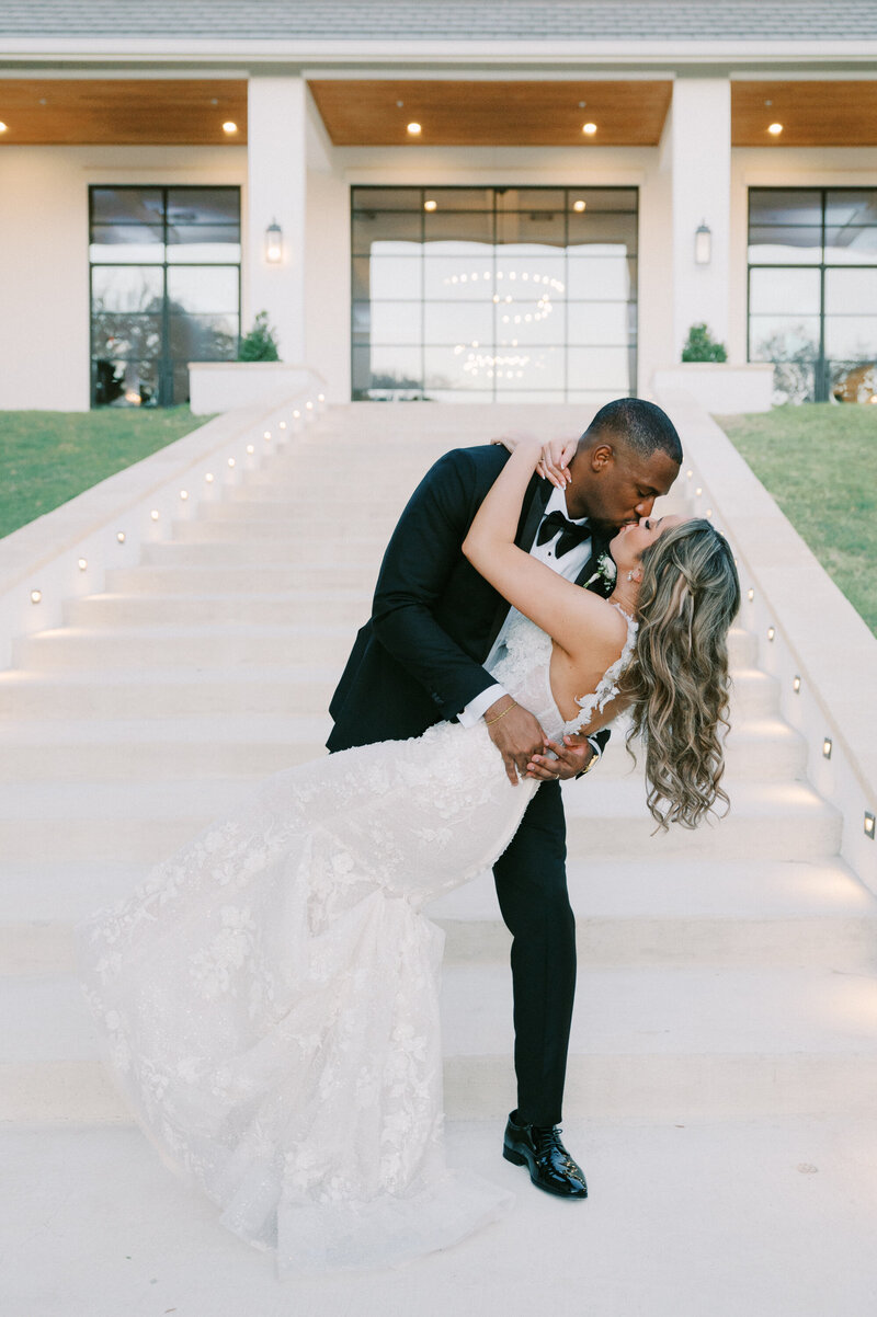 bride and groom dip kissing on stairs at austin wedding venue the arlo,, by austin wedding photographer