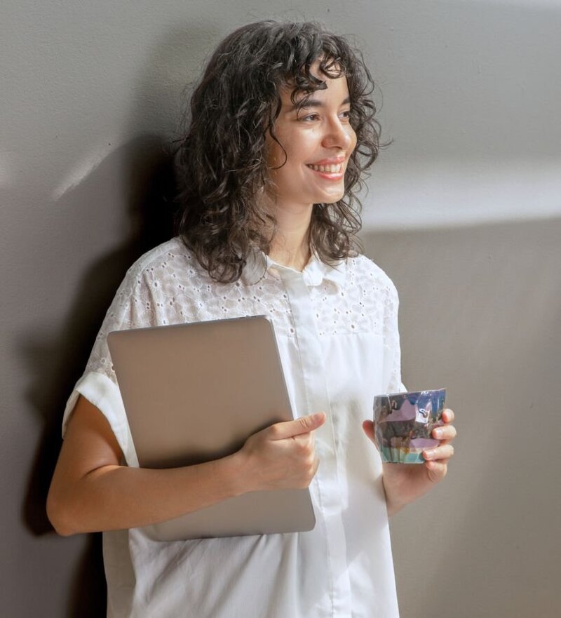 A smiling woman holding a laptop. EMDR therapy supports betrayal trauma recovery. Restore confidence with Relationship Experts in Florida.