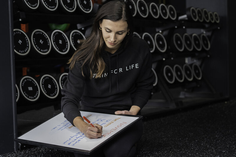 Train For Life's Personal Training taking notes about her upcoming personal training session and client.