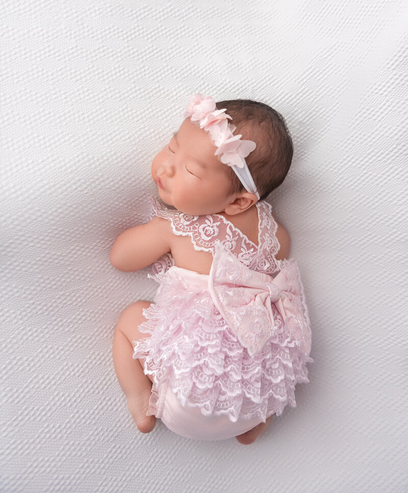 Baby in Pink dress with bow on a white backdrop