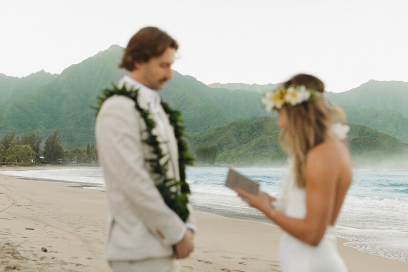 Bride and groom eloping in Kauai saying vows at Hanalei Bay
