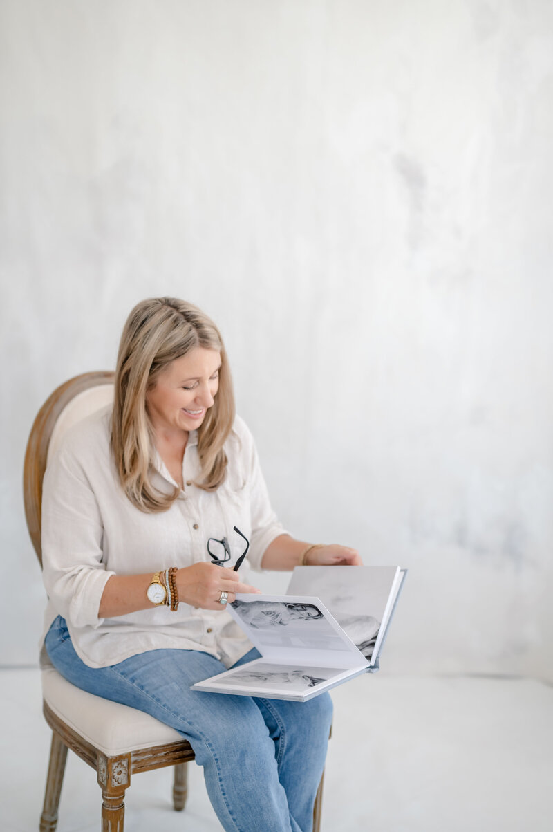 A woman flips through a luxury photo album at Little Palm Photography Studio in Northern California.